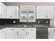 Close-up view of the kitchen sink, cabinets, and mosaic backsplash at 1291 Blackrush Dr, Tarpon Springs, FL 34689