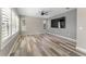 Spacious living room with natural light, wood-look floors, and a ceiling fan at 1291 Blackrush Dr, Tarpon Springs, FL 34689