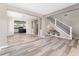 Open-concept living room with modern wood flooring, a staircase with black railings, and a view into the kitchen at 1291 Blackrush Dr, Tarpon Springs, FL 34689