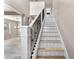 Bright staircase with white risers and black metal railings, complemented by stylish wood flooring and a chandelier at 1291 Blackrush Dr, Tarpon Springs, FL 34689