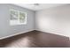 Bedroom features neutral walls, dark wood floors, ceiling fan, and a large window at 13384 Brighton St, Spring Hill, FL 34609