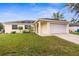 Charming one-story home featuring a two-car garage, manicured lawn, and vibrant landscaping at 13384 Brighton St, Spring Hill, FL 34609