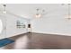 Open living room features hardwood floors, a window, a ceiling fan, and natural light at 13384 Brighton St, Spring Hill, FL 34609