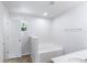 Bright bathroom featuring a sunken tub, neutral walls, and access to the restroom at 14006 Amero Ln, Spring Hill, FL 34609