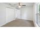 Bedroom featuring light brown carpet, a ceiling fan, a closet, and a window at 14006 Amero Ln, Spring Hill, FL 34609