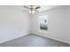 Bedroom with gray carpet, white walls, ceiling fan, and a window at 14006 Amero Ln, Spring Hill, FL 34609