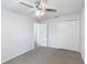 Bedroom features gray carpet, a ceiling fan, a closet, and hallway access at 14006 Amero Ln, Spring Hill, FL 34609