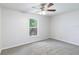 Bedroom featuring gray carpet, a ceiling fan, and a bright window at 14006 Amero Ln, Spring Hill, FL 34609