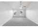 Bedroom with neutral carpet, white walls, ceiling fan and two windows at 14006 Amero Ln, Spring Hill, FL 34609