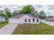 Charming single-story home with a pink exterior, well-manicured lawn, and attached garage at 14006 Amero Ln, Spring Hill, FL 34609
