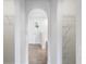 Hallway featuring arched doorways, storage shelves, and tiled floors leading to a bedroom at 14006 Amero Ln, Spring Hill, FL 34609