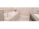 Clean bathroom featuring a soaking tub, granite countertops, and tile floors at 1674 Roseville St, Lutz, FL 33549