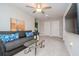 Cozy living room with plush gray sofa, modern ceiling fan, and mounted TV at 1674 Roseville St, Lutz, FL 33549