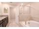 Bright main bathroom with a soaking tub, glass-enclosed shower, and granite vanity at 1674 Roseville St, Lutz, FL 33549