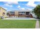 Beautiful backyard features a spacious deck, a sparkling pool, and plenty of green space at 17025 Dolphin Dr, North Redington Beach, FL 33708