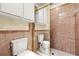 Bathroom featuring a tile shower, toilet, and storage cabinet at 17025 Dolphin Dr, North Redington Beach, FL 33708