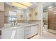 Bathroom featuring dual sinks, a large mirror, and a glass-enclosed shower at 17025 Dolphin Dr, North Redington Beach, FL 33708