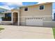 Exterior showcasing a spacious two-story home with a wide driveway and an attached garage, bathed in sunlight at 17025 Dolphin Dr, North Redington Beach, FL 33708