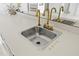Close up of kitchen sink with gold faucet and white countertop at 17025 Dolphin Dr, North Redington Beach, FL 33708