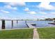 Waterfront home with lush lawn, dock, and view of homes across the water at 17025 Dolphin Dr, North Redington Beach, FL 33708
