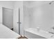 Well-lit bathroom featuring white tiled walls surrounding a tub-shower combo with a white vanity at 1830 Cameron Ct, Trinity, FL 34655