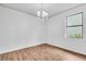 Empty bedroom featuring wood floors, large window, and modern chandelier at 1830 Cameron Ct, Trinity, FL 34655
