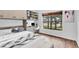 Staged bedroom with wood floors, study nook, and a large window with a view of mature trees at 1830 Cameron Ct, Trinity, FL 34655