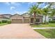 Charming home features a brick driveway, a two-car garage, and stone accents on the facade at 1830 Cameron Ct, Trinity, FL 34655