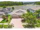 Beautiful home boasts lush landscaping and a brick driveway leading to a three-car garage and lake view at 1830 Cameron Ct, Trinity, FL 34655