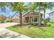 Charming home features a brick driveway, a two-car garage, and stone accents on the facade at 1830 Cameron Ct, Trinity, FL 34655