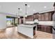 Modern kitchen with stainless steel appliances, granite countertops, and a large island with seating at 1830 Cameron Ct, Trinity, FL 34655