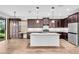 Well-equipped kitchen featuring dark cabinets, granite counters, a central island, and an adjacent breakfast nook at 1830 Cameron Ct, Trinity, FL 34655