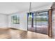Open-plan living space featuring hardwood floors, large windows, and sliding glass doors to pool at 1830 Cameron Ct, Trinity, FL 34655