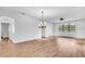 Bright living room with wood-look floors, an elegant chandelier and large windows for lots of natural light at 1830 Cameron Ct, Trinity, FL 34655