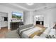 Staged main bedroom features wood floors, tray ceiling, an ensuite bath, and modern furniture at 1830 Cameron Ct, Trinity, FL 34655