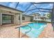 A screened-in pool area with brick pavers and a view of the backyard and surrounding landscape at 1830 Cameron Ct, Trinity, FL 34655