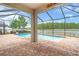 Screened-in pool area with brick pavers, a water view, and a covered outdoor space at 1830 Cameron Ct, Trinity, FL 34655