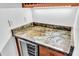 The wet bar showcases a unique marble countertop and an under-counter wine refrigerator at 1830 Cameron Ct, Trinity, FL 34655