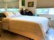 Cozy bedroom featuring a comfortable bed with patterned bedding, large windows, and tiled flooring for a tranquil living experience at 1865 Mazo Manor # 1, Lutz, FL 33558