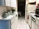 Functional kitchen featuring white cabinets, appliances, and a view into the bedroom at 1865 Mazo Manor # 1, Lutz, FL 33558