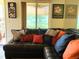 Inviting living room with a comfortable leather sectional and colorful pillows, bathed in natural light from a large window overlooking a lake at 1865 Mazo Manor # 1, Lutz, FL 33558