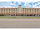 Low angle exterior of building with covered parking featuring a red tile roof and beige facade at 19029 Us Highway 19 N # 8-31, Clearwater, FL 33764