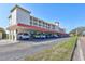 Building exterior with covered parking, red tile roof, balconies, and lush green lawn at 19029 Us Highway 19 N # 8-31, Clearwater, FL 33764