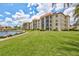 Multi-story condo building surrounded by lush green lawn and a tranquil pond at 19029 Us Highway 19 N # 8-31, Clearwater, FL 33764