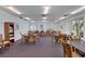 Well-lit game room with tables, chairs, and a bookcase offering a comfortable space for leisure at 19029 Us Highway 19 N # 8-31, Clearwater, FL 33764