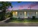 Charming white home with blue shutters, lush landscaping, and a welcoming dusk sky at 1903 Canterbury Ln # B24, Sun City Center, FL 33573