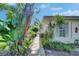 Landscaped walkway leading to the house with lush tropical foliage and plants at 1903 Canterbury Ln # B24, Sun City Center, FL 33573