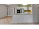 Kitchen view with white cabinets, stainless steel appliances, and breakfast bar overlooking the living area at 1903 Canterbury Ln # B24, Sun City Center, FL 33573