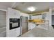 This updated kitchen features white cabinets, granite countertops, and stainless steel appliances at 1903 Canterbury Ln # B24, Sun City Center, FL 33573
