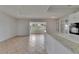 Open-concept living space featuring tile flooring, modern lighting, and adjacent kitchen area at 1903 Canterbury Ln # B24, Sun City Center, FL 33573
